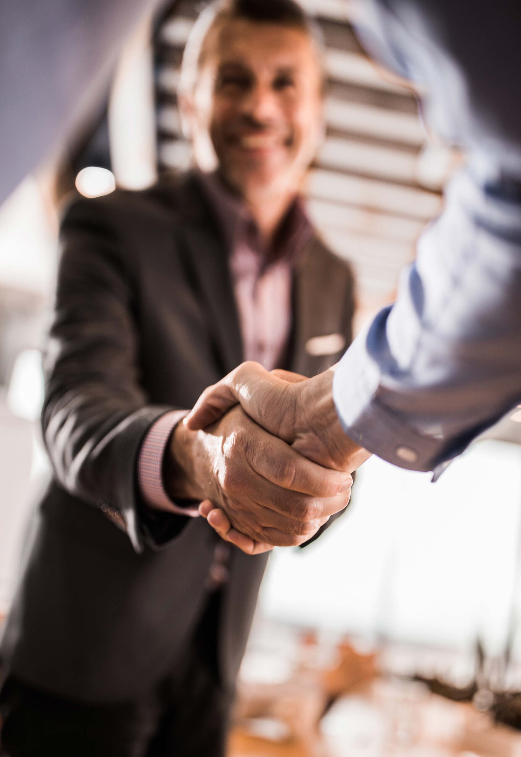 Ein Mann gibt lächelnd einem anderen Mann die Hand.